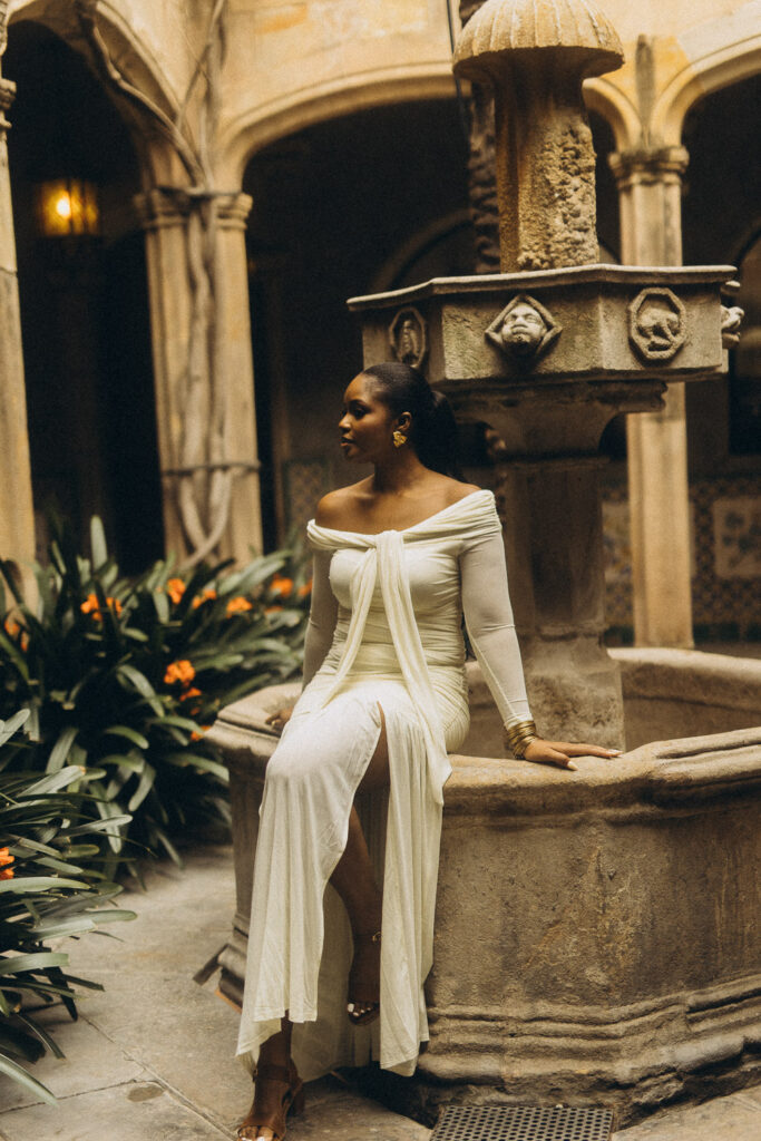 Stylish woman posing in front of ancient stone walls in the Gothic Quarter