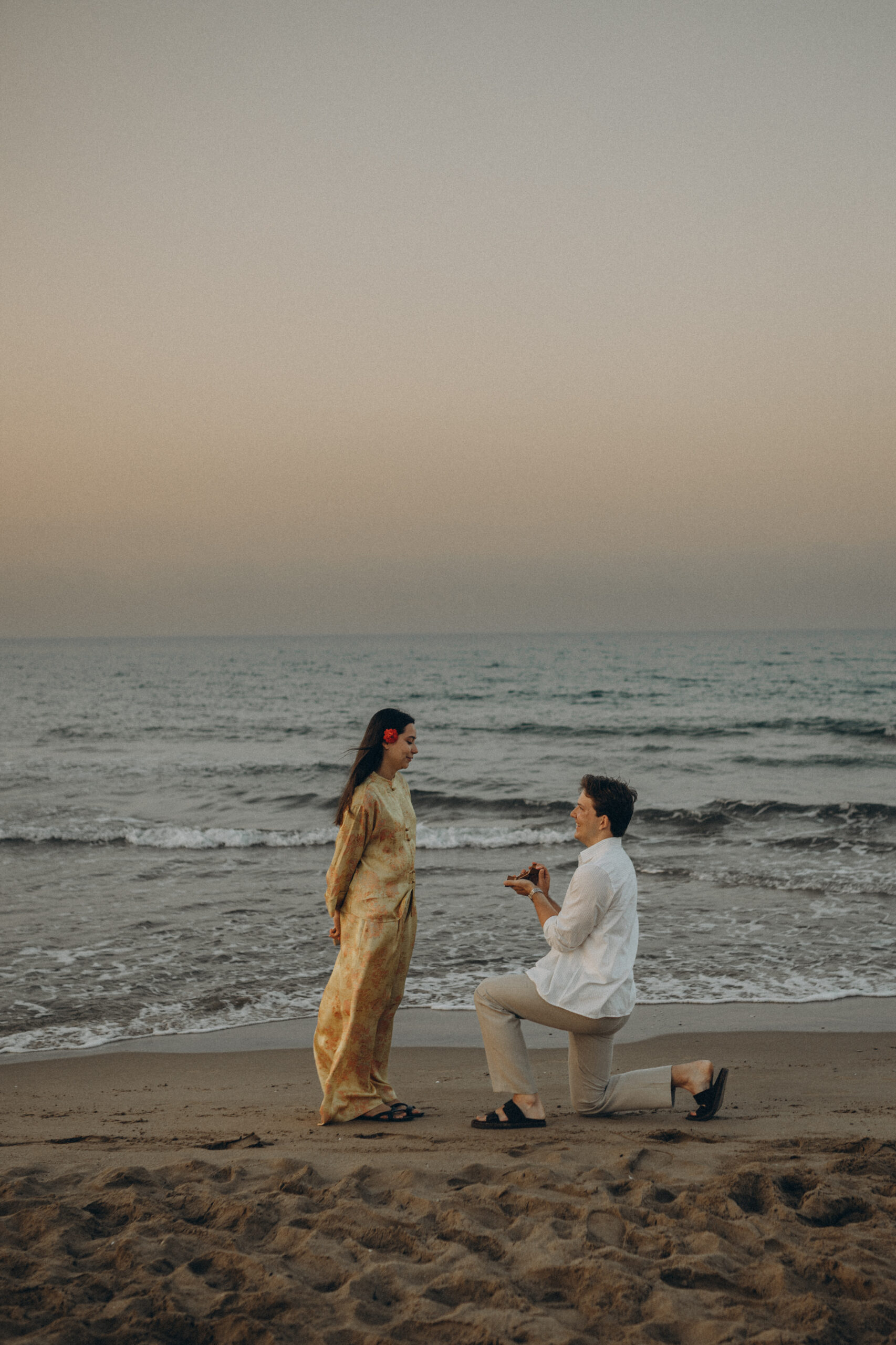 He is proposing sitting on one knee by the sea in Barcelona at sunrise