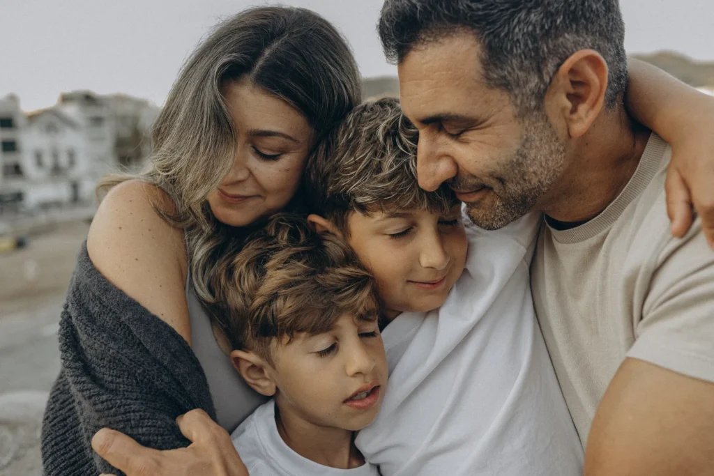 Family portrait in Barcelona — parents and children in a warm embrace