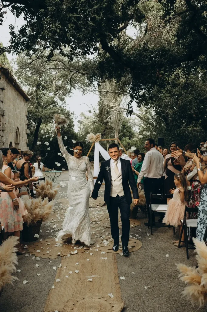 Wedding photographer Barcelona — bride and groom leaving ceremony with petals